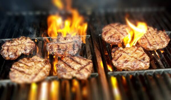 Burger Patties auf dem Grill bereit zum würzen